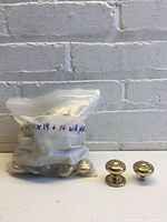 Bag containing knobs and two sample knobs with and without backplates