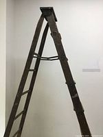 Full view of ladder partially opened showing A-frame shape and metal top