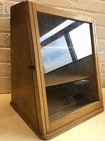 Front view showing slanted glass door and interior shelves