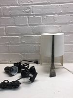 Overall view showing Ikea lamp with paintbrush leg and two black clamp lights