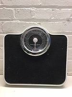 Front view of Starfrit analog bathroom scale showing dial and platform