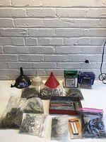 Full lot overview showing funnels, boxes, bags of hardware, red case