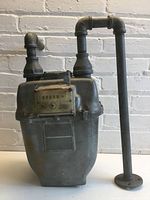 Front view of galvanized gas meter showing register and pipe connectors