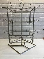 Front view of metal rotating display rack showing tiers and hooks