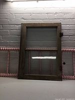 Front view of wood two-pane window and partial pink ladder