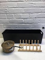 Overall view of dish rack, copper saucepan, wooden lid holder