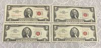 Front view of all four $2 red seal notes showing series, serial numbers and red seals