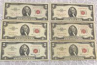 Front view of six US $2 red seal notes displaying denominations, serial numbers and condition