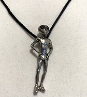 front view of full necklace showing alien pendant on black cord