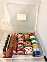 Overall view of plastic case with lid open showing all ribbon spools neatly arranged