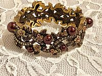 Front angle of ornate bracelet showing faux pearls and rhinestones