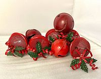 Group of eight red metal jingle bells showing both mesh-covered and solid styles