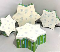 Front view of four nested snowflake boxes with lids on