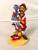 Front view of resin elf figurine holding rag doll