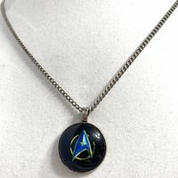 Front view of pendant on chain showing Starfleet emblem design