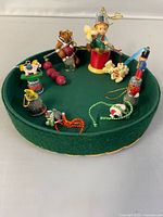 All six Enesco thimble ornaments displayed on round green pad