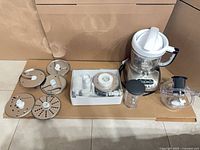 Overall lot showing processor base, bowls, discs, storage box, blending cup