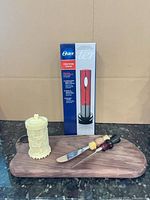 Group shot showing boxed Oster wine opener set, carved container, wood board, spreader and fork