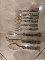 All nine utensils laid out on tile floor showing fronts