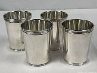 Four silver-plated cups grouped front view