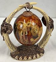 Full view of decorated ostrich egg on faux tusk stand