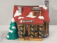 Front view showing porch, sign, tree, and roof detail