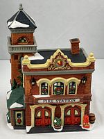 Front view showing twin red doors, FIRE STATION sign, wreaths