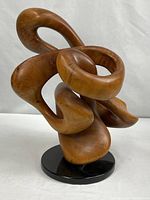 Full view of wood sculpture on black stone base