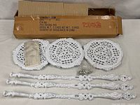 All components laid out: three lattice shelves, three decorative legs, hardware bag, instructions, shipping box