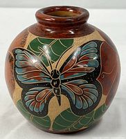 Full view of rounded butterfly motif pottery vase