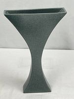Full view of gray ceramic vase showing hourglass shape and matte finish