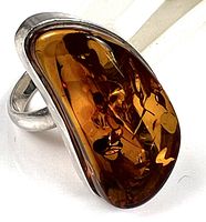 Front view of sterling silver ring with amber-tone acrylic cabochon