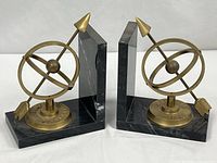 Pair of black marble and brass armillary sphere bookends front view