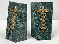 Front view of both marble bookends showing brass caduceus emblems