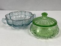 Aqua handled dish beside green covered dish showing overall forms and colors