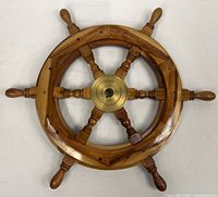Front view showing full six-spoke wooden ship wheel with brass hub