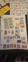 Notebook page with assorted Canadian stamps and a partial sheet in upper frame