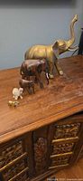 All five elephant figurines displayed on wooden surface