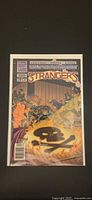 Front cover of The Strangers #9 comic in bag and board