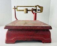 Front view of red cast iron platform scale with brass beam