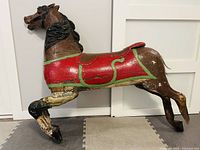 Right side full view showing overall form, red saddle, missing back left hoof