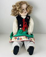 Full view of seated doll showing costume and size proportion