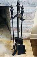 Full view of wrought iron stand with broom, poker and shovel