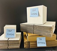 All three stacks of flat-packed boxes with one assembled sample of each size displayed