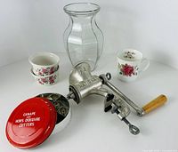 All items group shot showing meat grinder, tin of cutters, glass vase, floral mug, pair of dishes