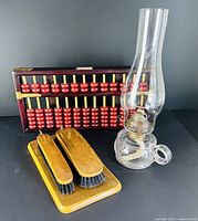 Group shot showing abacus, oil lamp, and shoe shine set