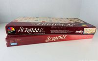 Two Scrabble boxes stacked showing side panels for edition identification