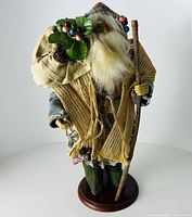 Full front view of Santa figurine showing base, attire, staff and bag