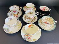 Seven teacup and saucer sets displayed together