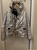 Front view of metallic silver Diesel quilted hooded jacket on hanger